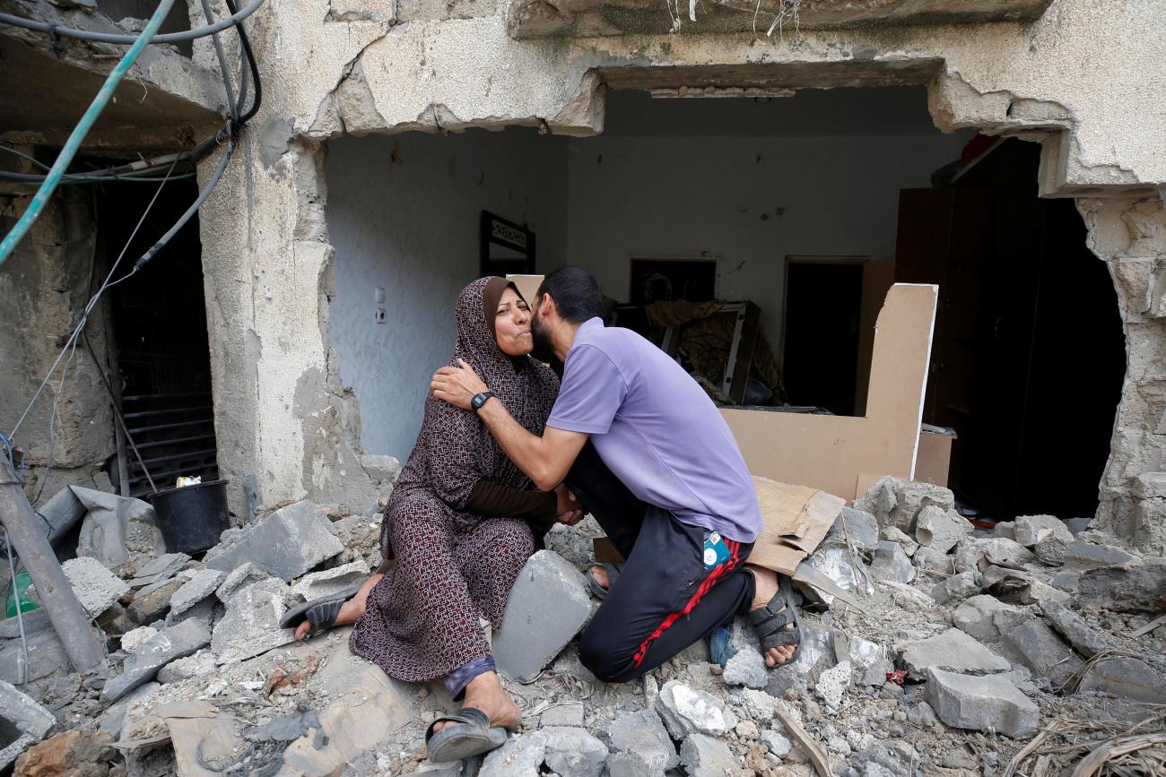 A Palestinian woman is kissed by her son after returning to their destroyed house following the Israel-Hamas truce, in Beit Hanoun in the northern Gaza Strip on May 21, 2021. REUTERS/Mohammed Salem