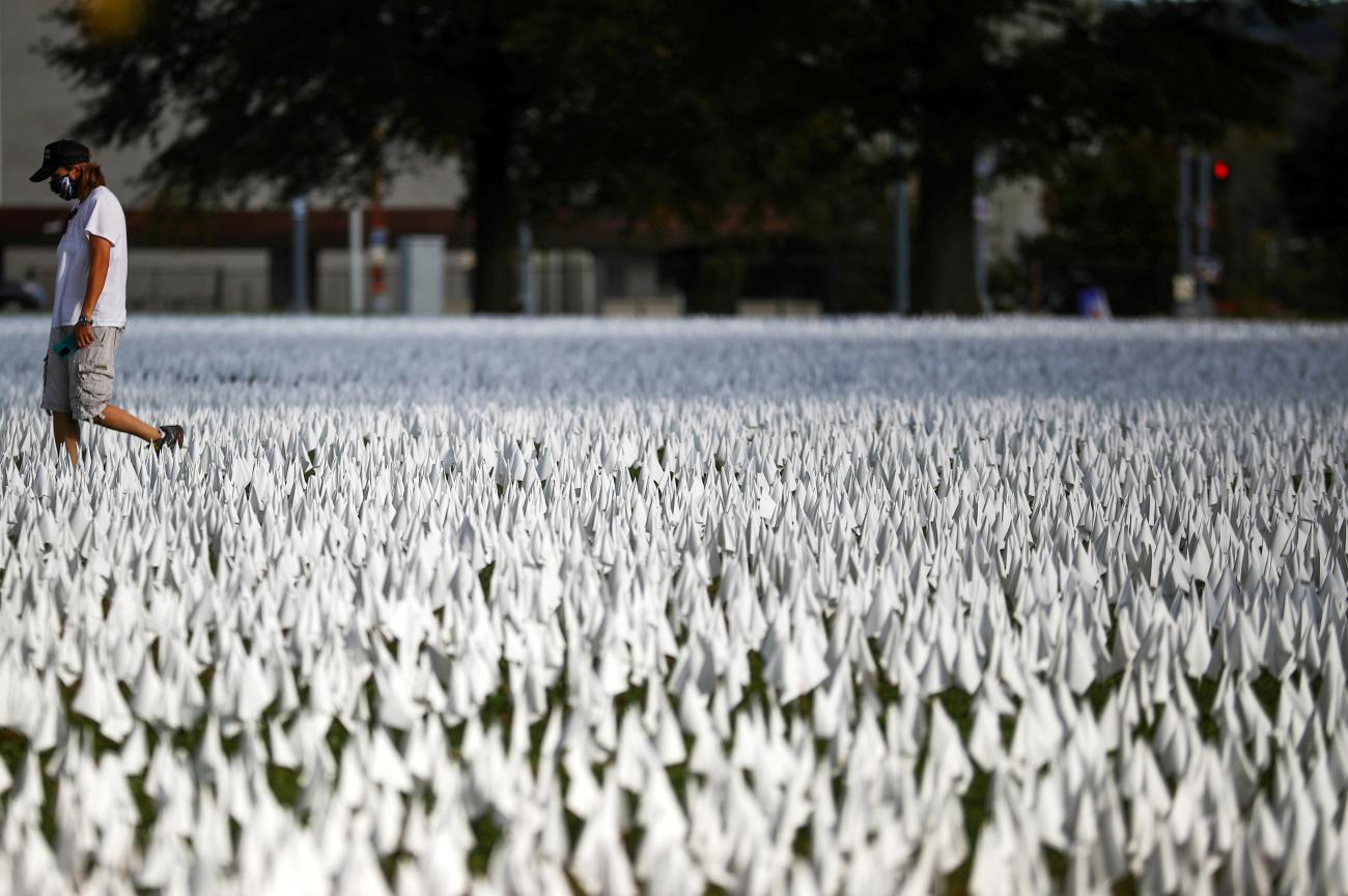 A person walks past the art installation "IN AMERICA How Could This Happen..." by artist Suzanne Brennan Firstenberg, as the spread of the coronavirus disease (COVID-19) continues, on the DC Armory Parade Ground, in Washington D.C., U.S., October 23, 2020.