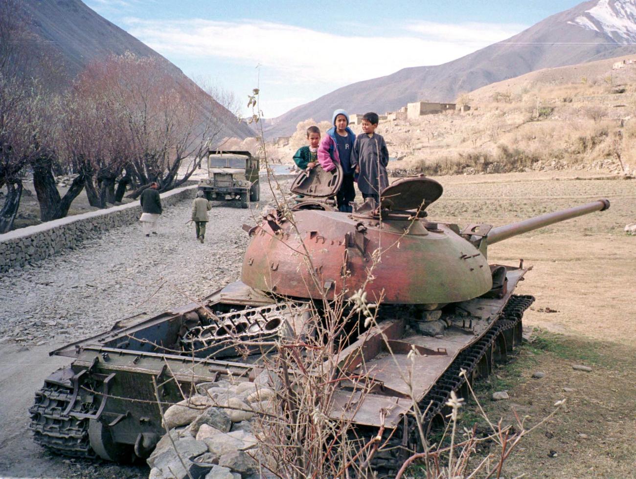 Afghan children in the Panjsher valley December 9 play on a gutted Russian tank which was destroyed by mujahideen guerrillas during the Soviet invasion of Afghanistan in 1978. Thousands fled their homes north of Kabul for the sanctuary of the Panjsher when the Taleban launched a summer offensive to crush Ahmad Shah Masood, their last major opponent.