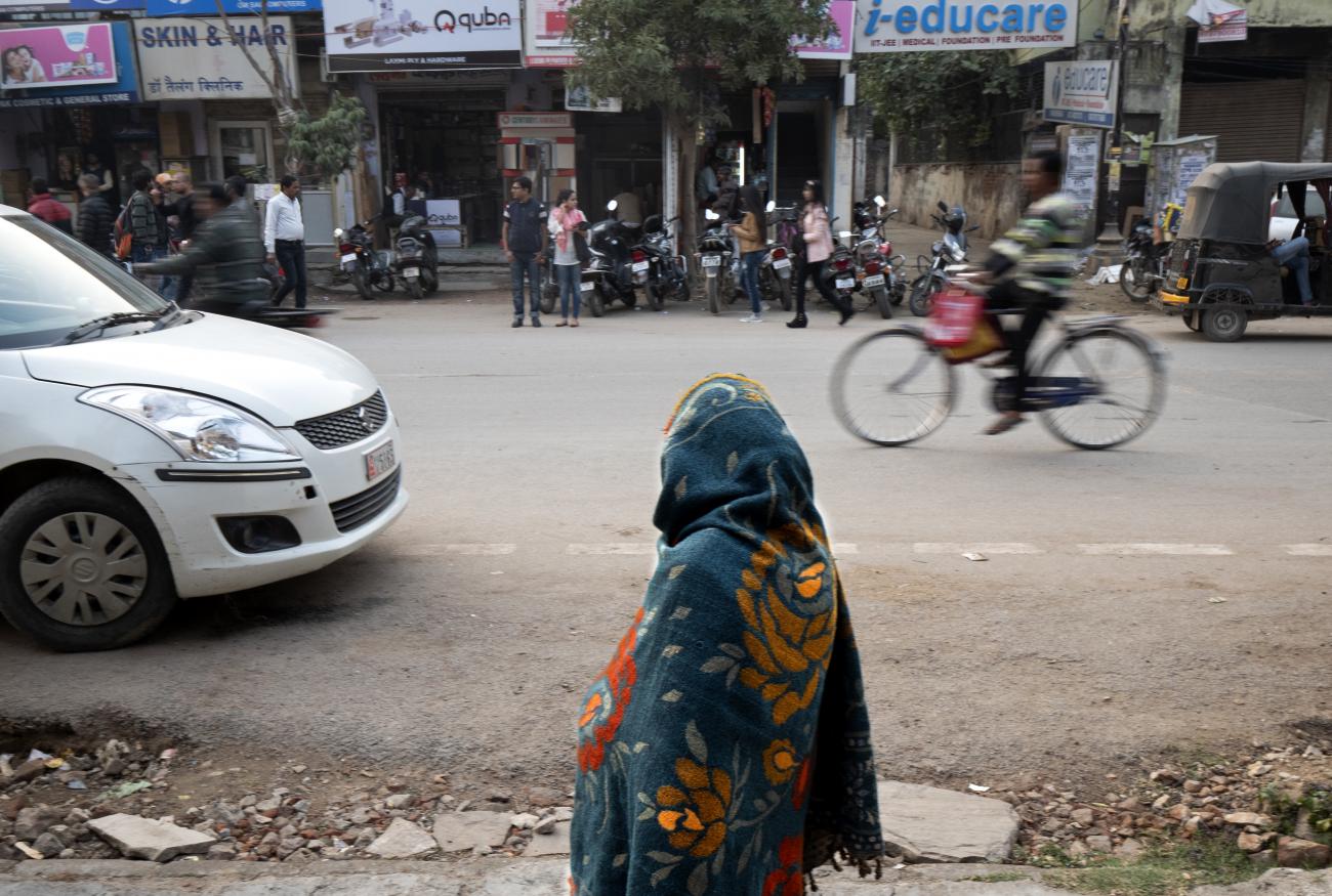 A widow looks out onto street traffic from the courtyard of the Durga Kund Help Line ashram in Varanasi, India. Thousands of widows flock to Varanasi, a holy city, in escape of abusive family members.