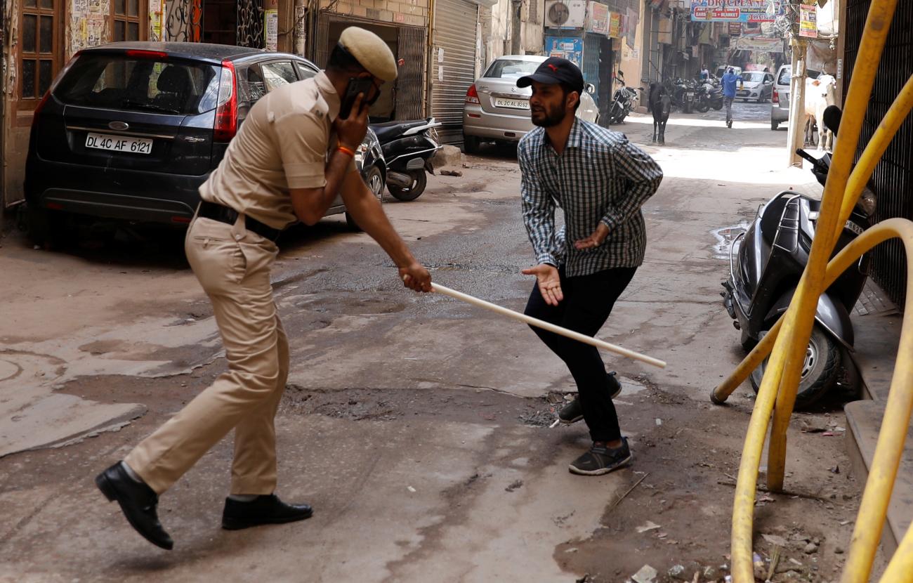 A police officer wields his baton against a man as a punishment for breaking the lockdown rules after India ordered a 21-day nationwide lockdown to limit the spread of coronavirus disease (COVID-19), in New Delhi, India, March 25, 2020.
