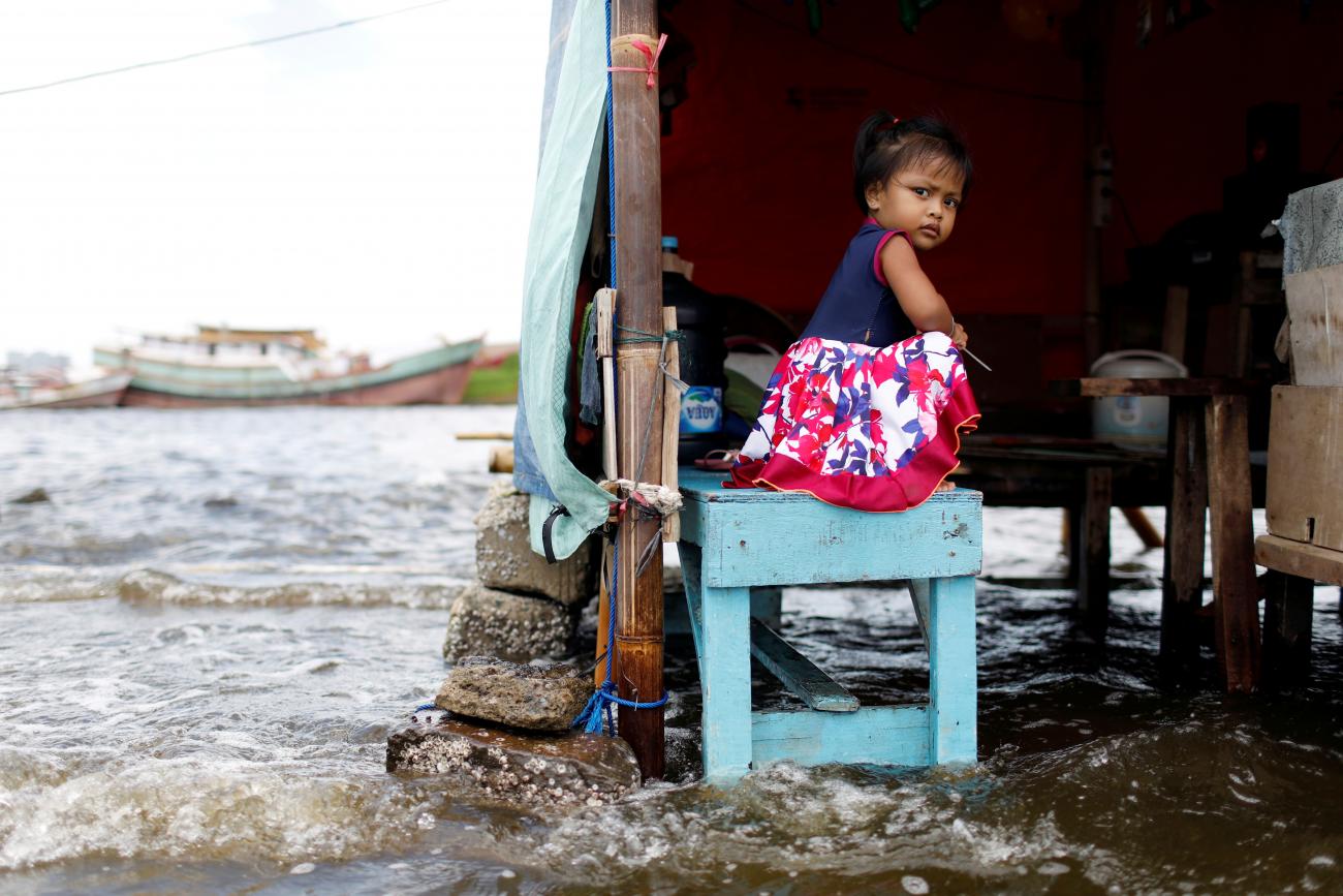 A young girl sits on a bench at Kali Adem port, which is impacted by high tides due to the rising sea level and land subsidence, north of Jakarta, Indonesia November 20, 2020.