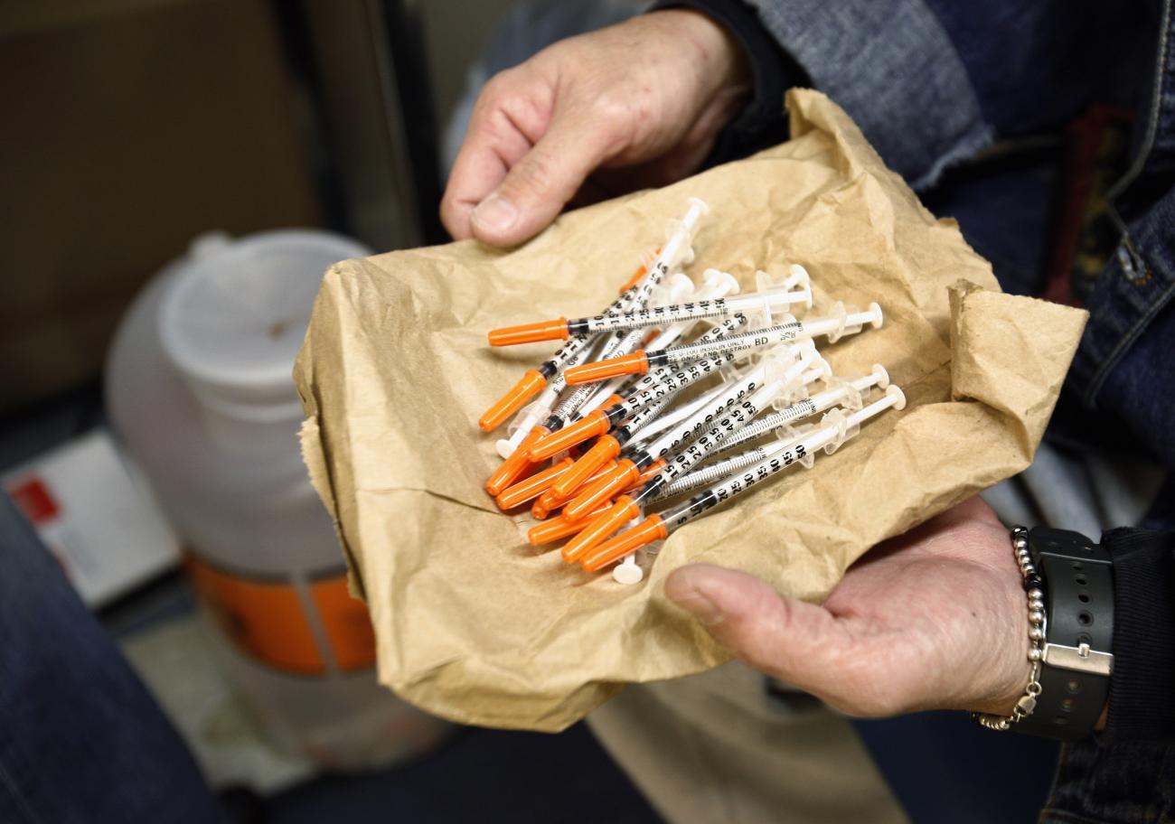 A woman shows her clean syringes at the Aids Center of Queens County needle exchange outreach center in New York, November 28, 2006. Participants bring used syringes to the program, and trade them for clean ones.