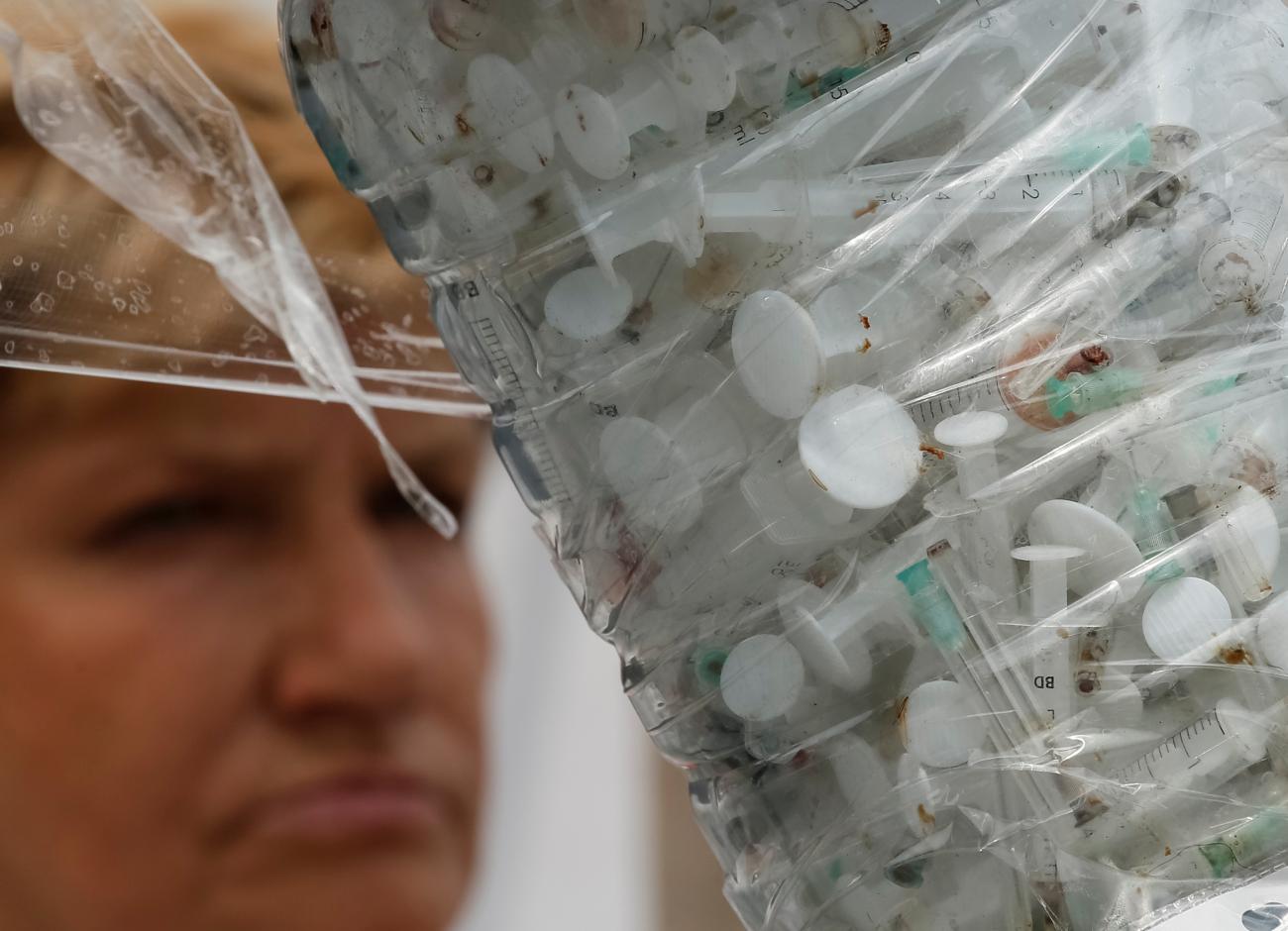 Used syringes are seen as activists campaigning for a better legal treatment of drug offenders take part in a performance to mark the International Day against Drug Abuse and Illicit Trafficking and the International Day