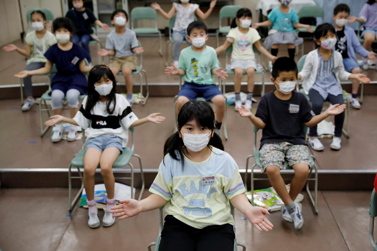 Students wearing face masks amid the COVID-19 outbreak, clap along instead of singing a song during a music class at Takanedai Daisan elementary school, in Funabashi, Japan, on July 16, 2020.