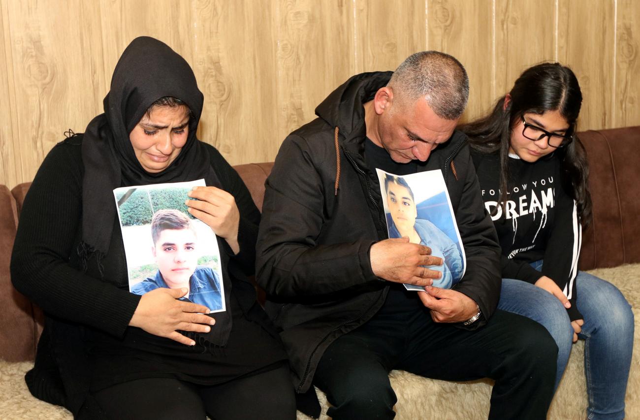 Parents of Miran, who died in a car accident, react while they hold his pictures at their home in Sulaimaniya, Iraq, on December 18, 2018.