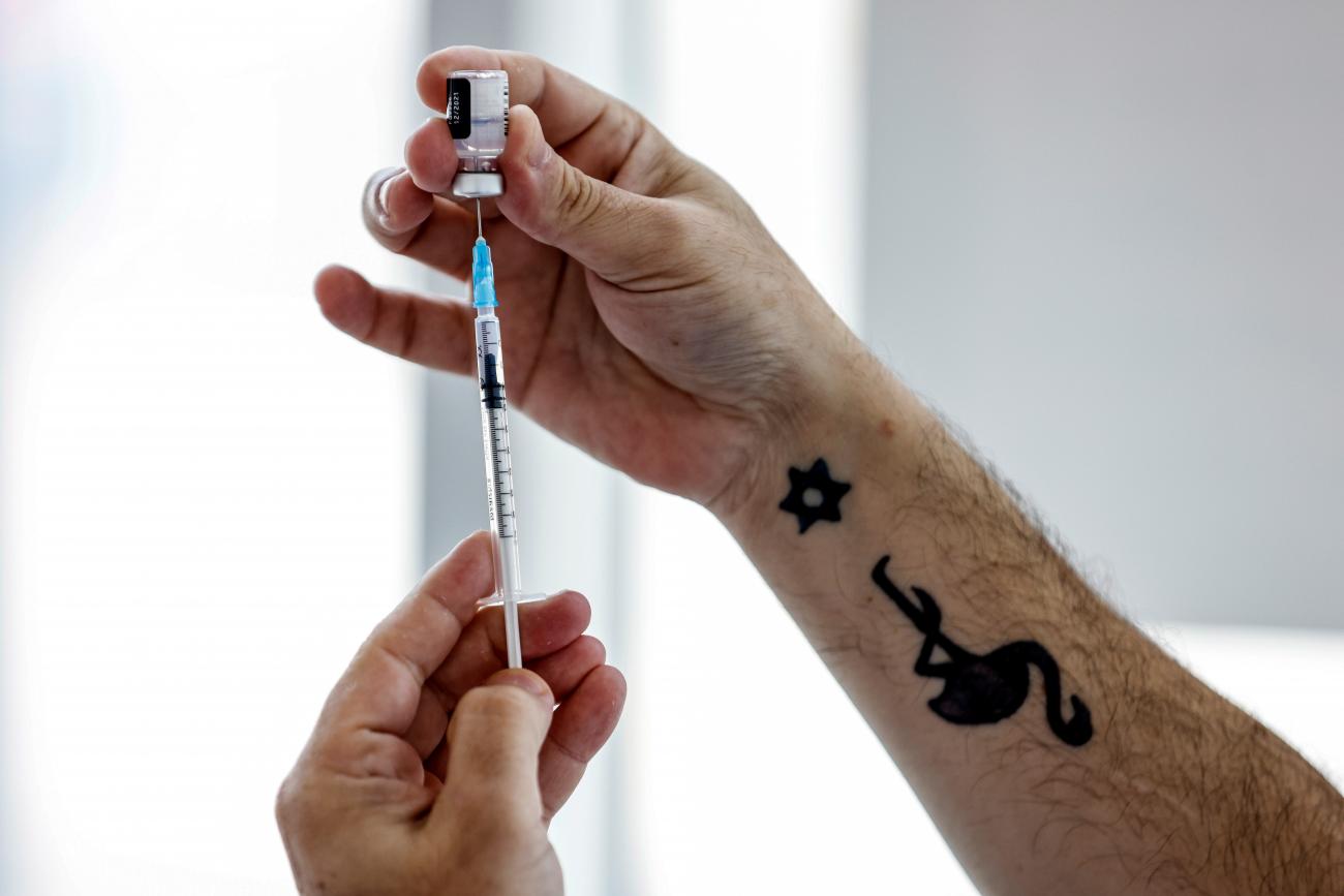 A medical worker with a tattoo prepares to administer a patient's third dose of the coronavirus vaccine in Tel Aviv, Israel, on August 30, 2021. 
