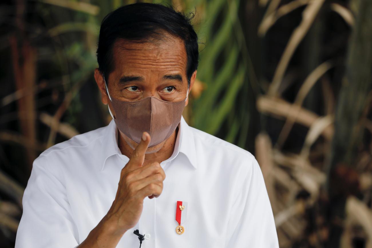 Indonesian President Joko Widodo wearing a protective mask gestures during an interview in Bebatu, near Tarakan, North Kalimantan province, Indonesia, on October 19, 2021