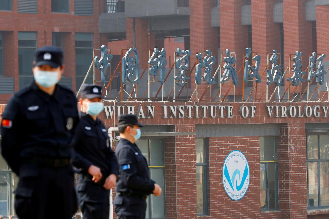 Security personnel keep watch outside Wuhan Institute of Virology during a visit by a WHO team investigating the origins of COVID, in Wuhan, Hubei province, China, on February 3, 2021.