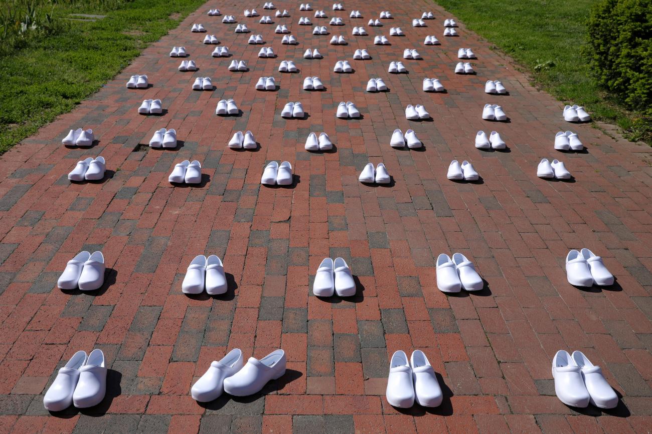 Rows of white shoes are laid out in memory of health-care workers who died from COVID-19 during a demonstration by nurses at the White House in Washington, DC, May 7, 2020. 
