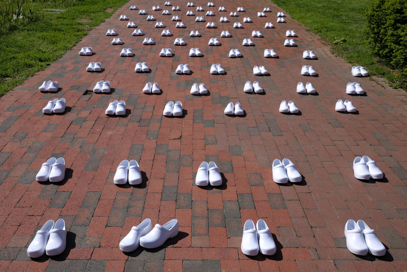 Rows of white shoes are laid out in memory of health-care workers who died from COVID-19 during a demonstration by nurses at the White House in Washington, DC, May 7, 2020.