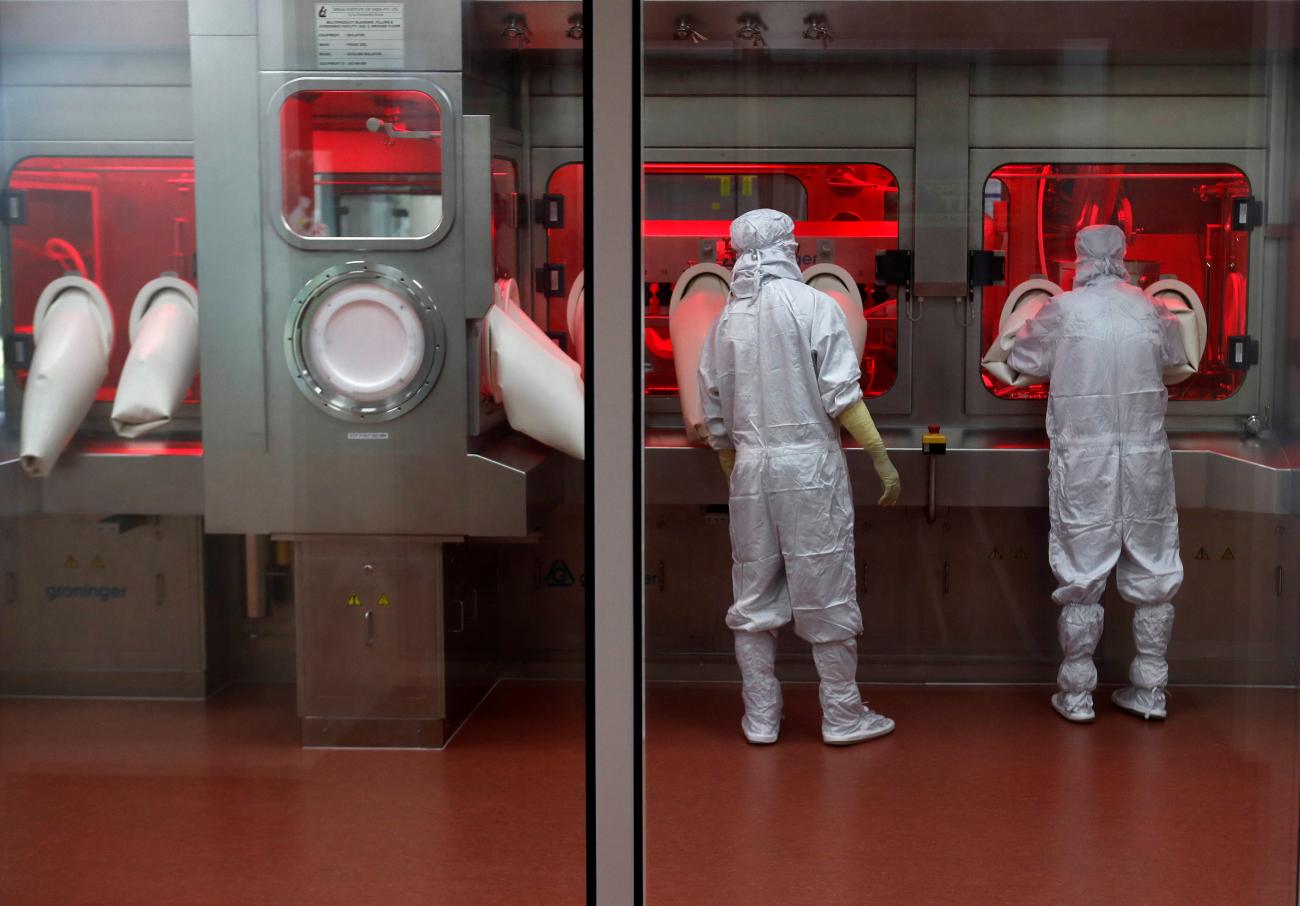 Employees operate a filling machine inside a lab at the Serum Institute of India, in Pune, India, on November 30, 2020. 