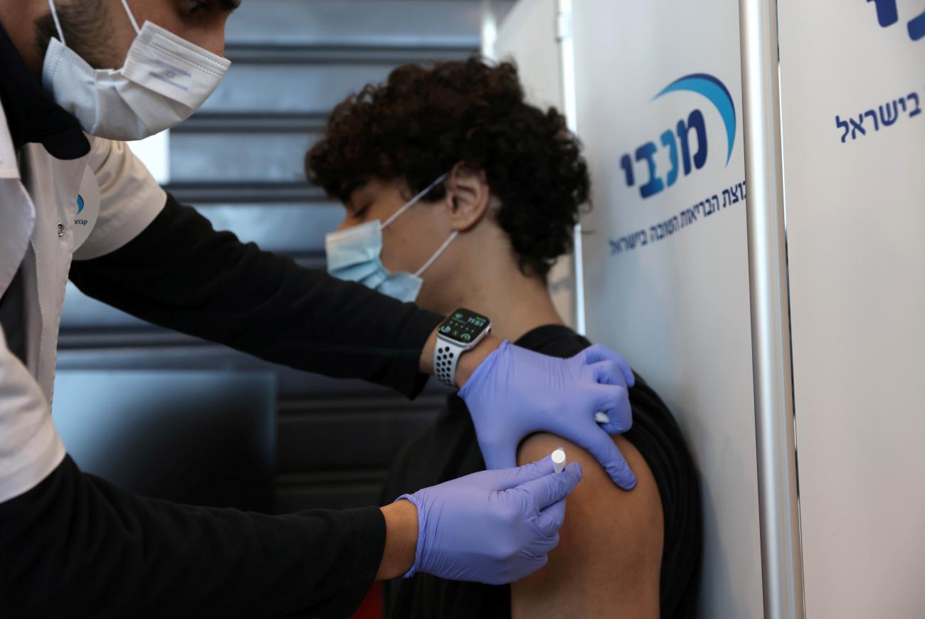 A teenager receives a vaccination against the coronavirus disease, in Tel Aviv, Israel, January 24, 2021. Photo by REUTERS/Ronen Zvulun