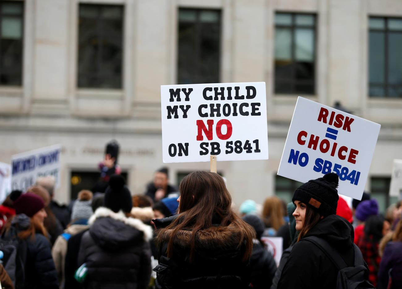 People protest mandatory vaccinations, waving "My Child, My Choice" signs during a "March for Medical Freedom" in Olympia, Washington, on February 20, 2019.