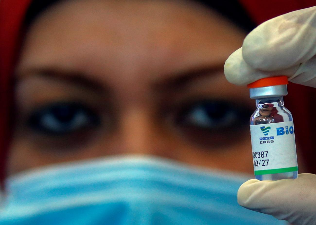 A close-up photo shows the eyes and mask of a nurse holding up a vial of China's Sinopharm COVID-19 vaccine at a vaccination venue at the International Exhibition Center in Cairo, Egypt, on June 2, 2021.
