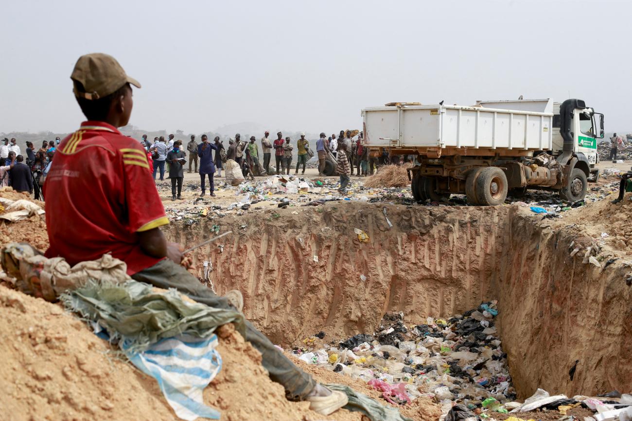 People await the discharge of expired AstraZeneca coronavirus disease (COVID-19) vaccines at the Gosa dump site in Abuja, Nigeria December 22, 2021.