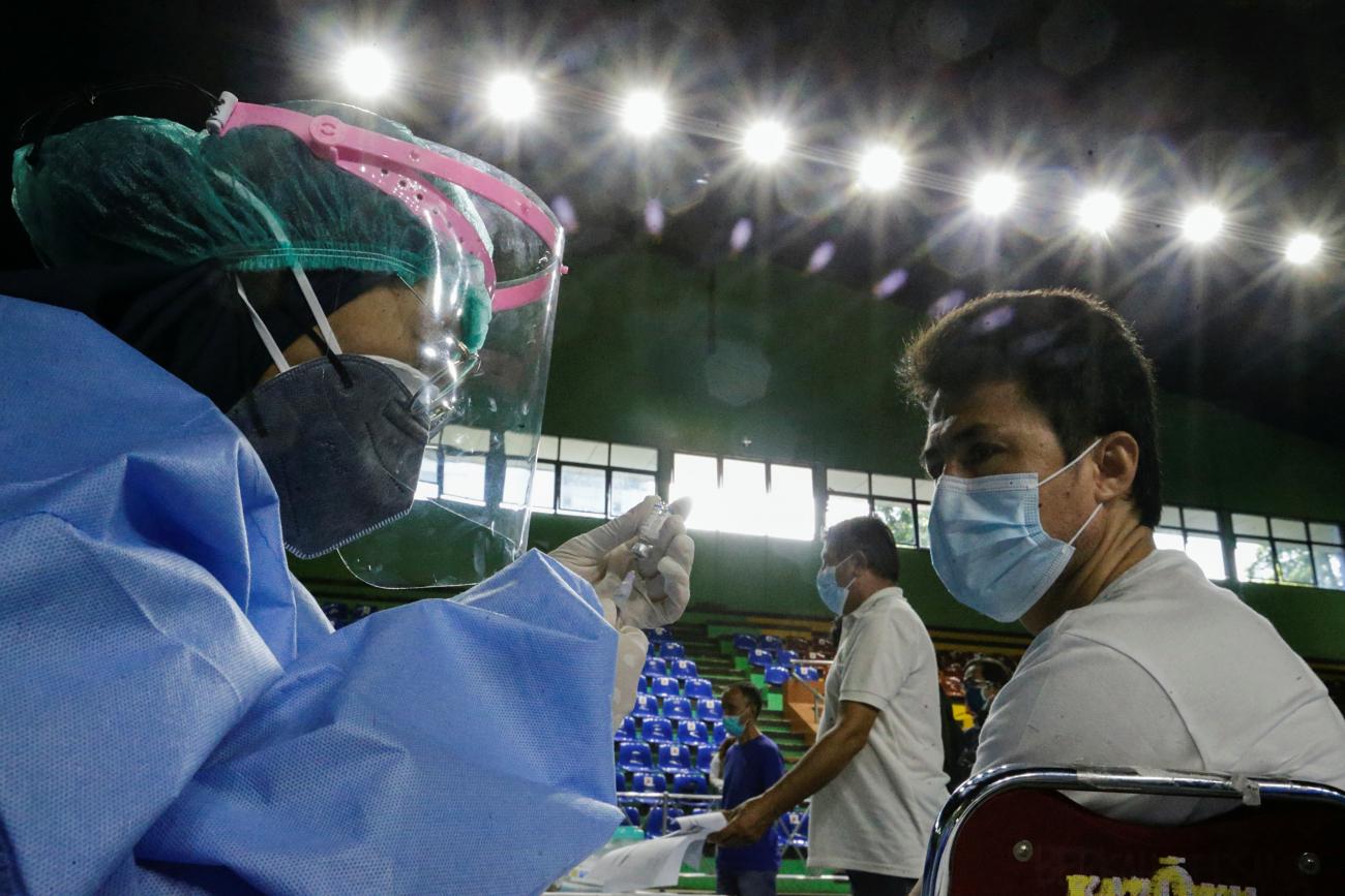 A health-care worker prepares a COVID-19 vaccine dose during a mass vaccination program for asylum seekers and refugees at a sports hall in Jakarta, Indonesia, on October 7, 2021.