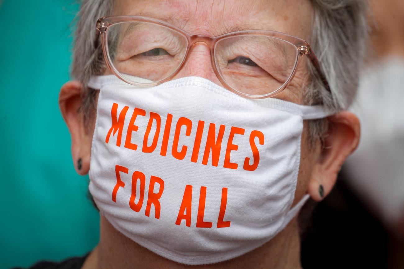 An activist wearing a white face mask that says "Medicines for All" in orange print attends a rally for global access to COVID-19 vaccines, outside the German Consulate in New York City on July 14, 2021.  Photo by REUTERS/Brendan McDermid