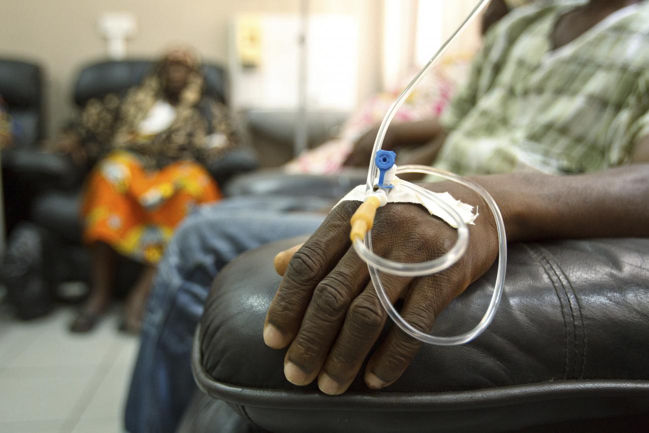 A man in a leather arm chair receives chemotherapy through an IV in his hand.