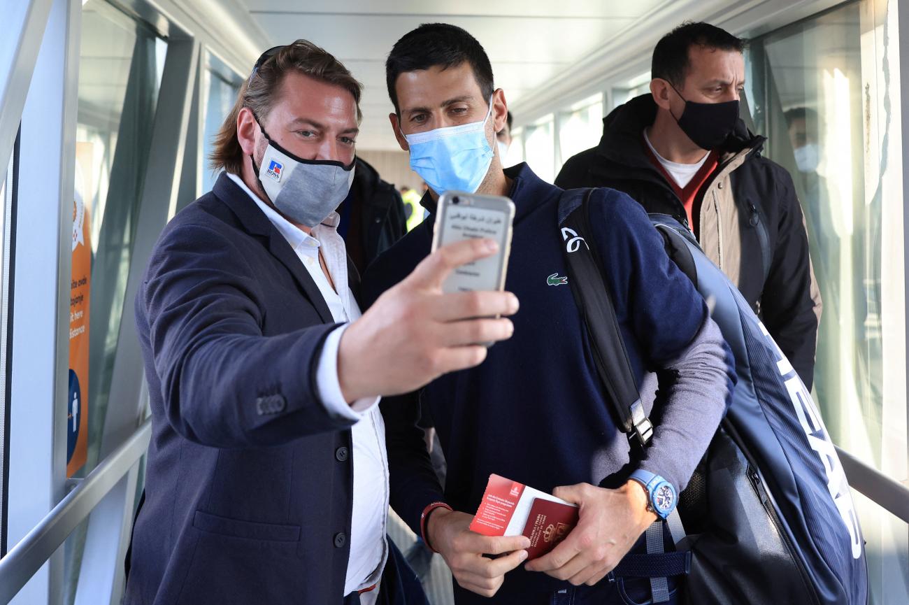 A man takes a selfie with Serbian tennis player Novak Djokovic as he arrives at Nikola Tesla Airport, after the Australian Federal Court upheld a government decision to cancel his visa to play in the Australian Open, in Belgrade, Serbia January 17, 2022. 