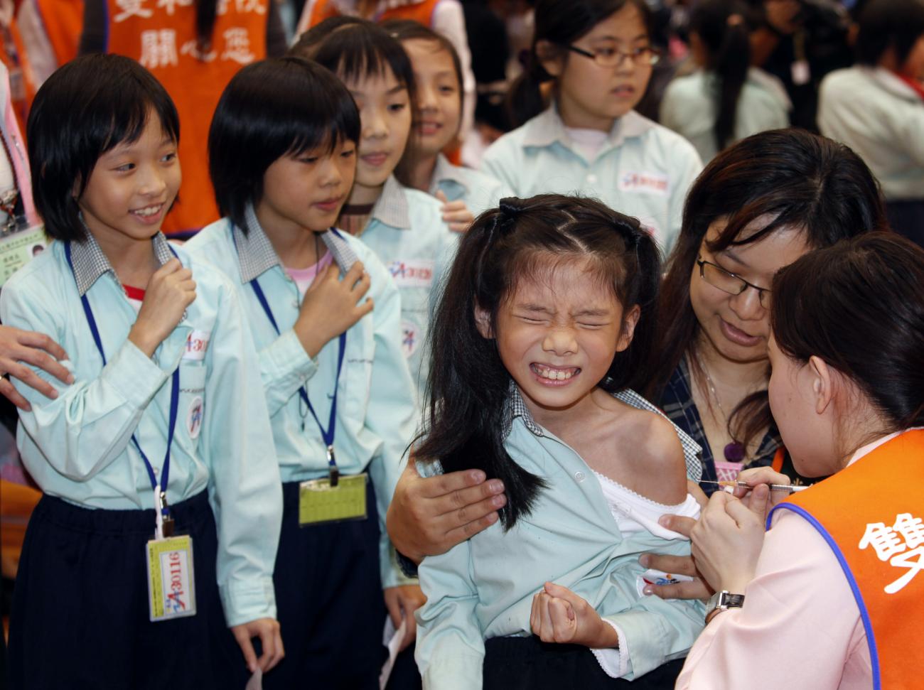 A girl reacts as she receives an Influenza A (H1N1) vaccine inside an elementary school in Taipei County, Taipei, China, on November 16, 2009. 