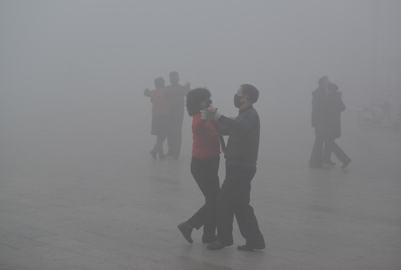 Pairs of masked dancers glide through heavy smog on a polluted day in Fuyang, Anhui province, China, on January 3, 2017. 