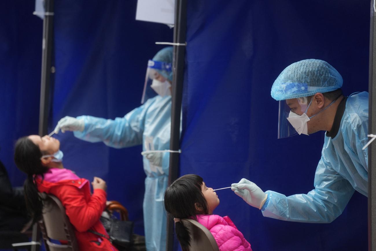 Medical workers take swab samples from residents at a community nucleic acid testing centre for the coronavirus disease at Sha Tin District, in Hong Kong, on February 7, 2022.  REUTERS/Lam Yik