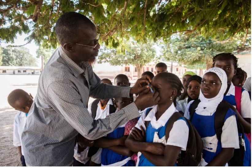 Ebrima, a teacher in Brikama, Gambia, examines school children's eyes for signs of trachoma.