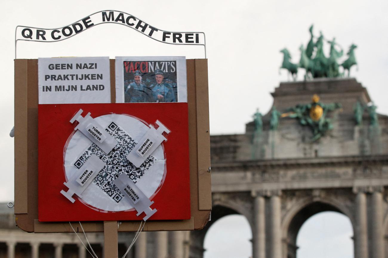 A person holds an anti-vaccination placard during a demonstration against the Belgian government's restrictions imposed to contain the spread of the coronavirus disease (COVID-19) in Brussels, Belgium January 9, 2022. The placard reads: "QR code make you free. No Nazi practices in my country".