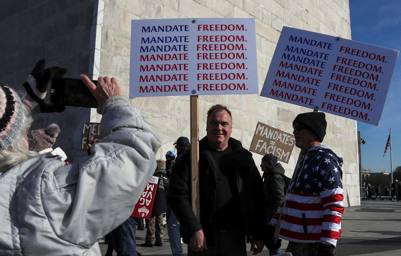 People pose next to the Washington Monument on the National Mall as they gather for the anti-vaccine mandate march in Washington, DC, on January 23, 2022.