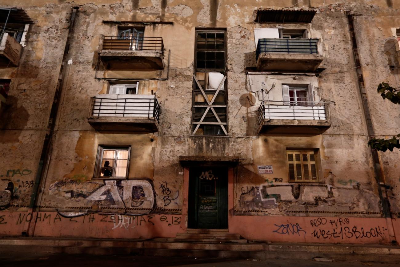 A man is silhouetted speaking on the phone inside an apartment at the "Prosfygika" housing complex in Athens November 1, 2013. 