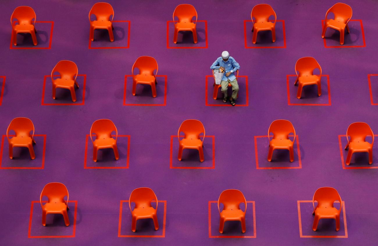 A man sits amongst empty seats at a free movie screening as restrictions on social gathering are tightened due to the surge of cases in the COVID-19 outbreak, in Singapore, on September 29, 2021.