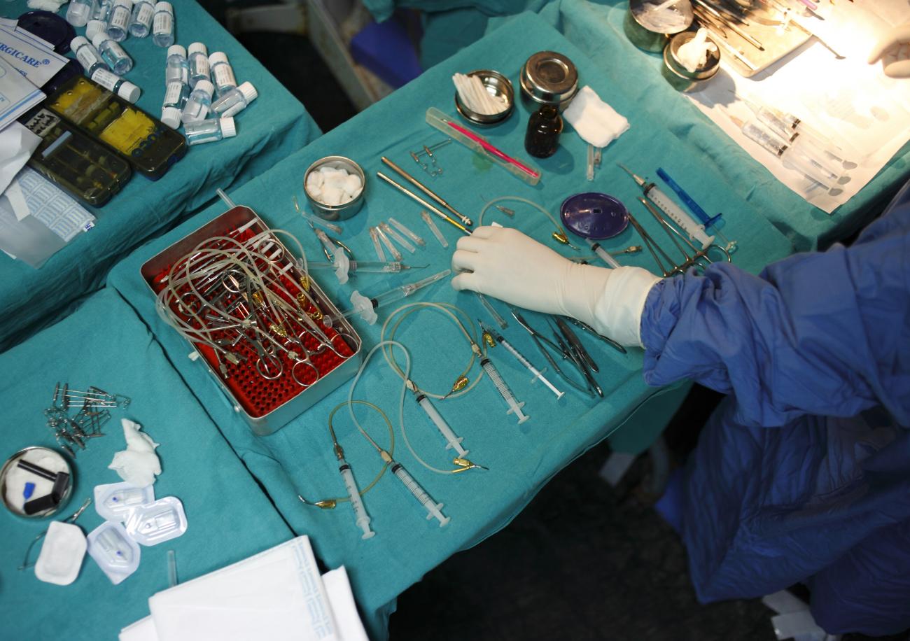 A nurse passes equipments laid out on a table to a surgeon during a cataract surgery at the Tilganga Eye Center in Kathmandu, Nepal, on April 25, 2012.