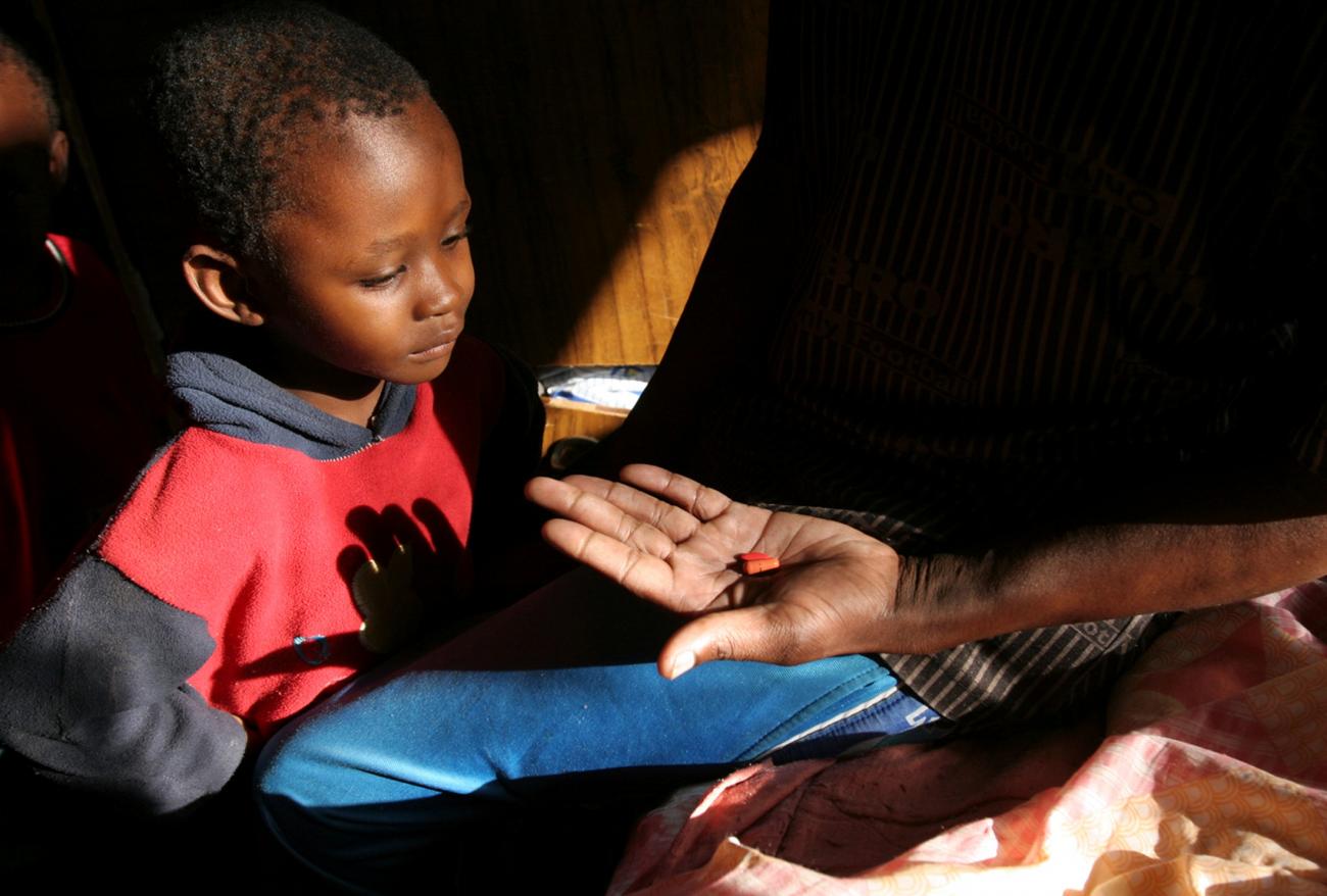 A man taking part in a clinical trial for HIV/AIDs treatment shows medicine to his son, who is HIV-negative in Gabarone, Botswana