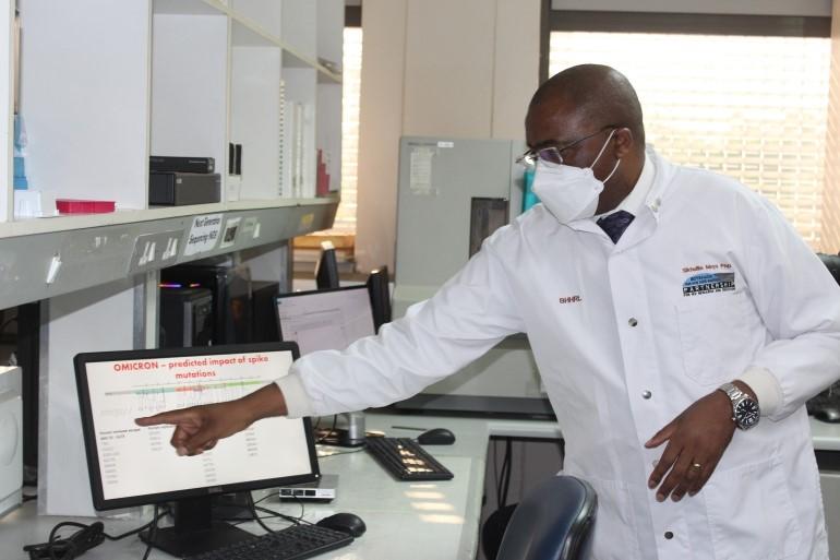 Dr. Sikhulile Moyo points to a computer, describes his team’s findings during a visit by President of Botswana, Mokgweetsi Masisi, December 2, 2021.