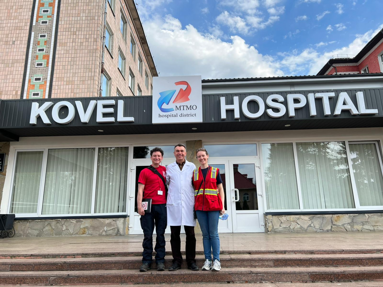 CMAT's David Thanh (left), a search-and-rescue and mobile clinic specialist, and Sarah Scott (right), an emergency physician, with a local doctor at Kovel Hospital in western Ukraine, March 2022.