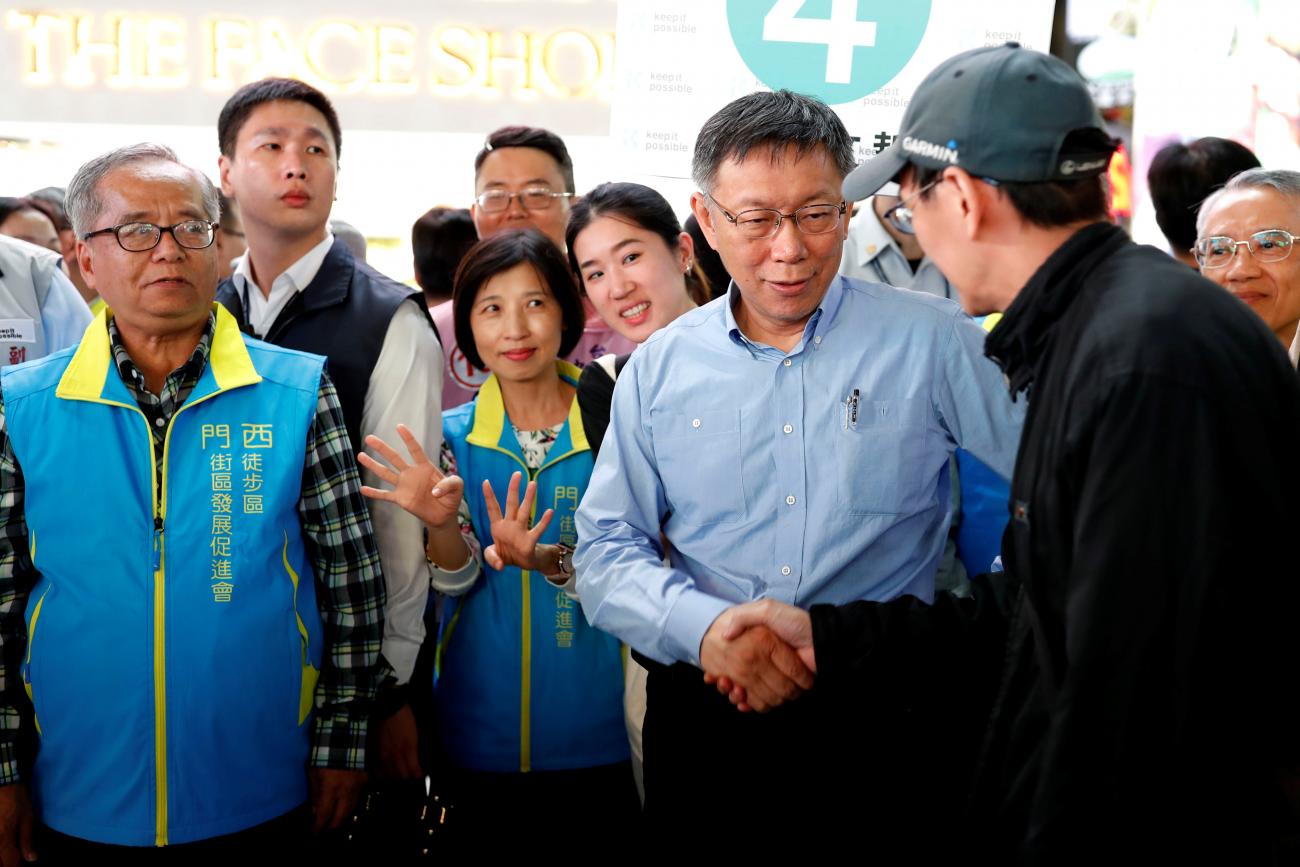Taipei mayor Ko Wen-je (2nd-R), wears a light blue collared shirt as he shakes the hand of a supporter in a baseball cap ahead of upcoming local elections, in Taipei, Taiwan November 20, 2018. 