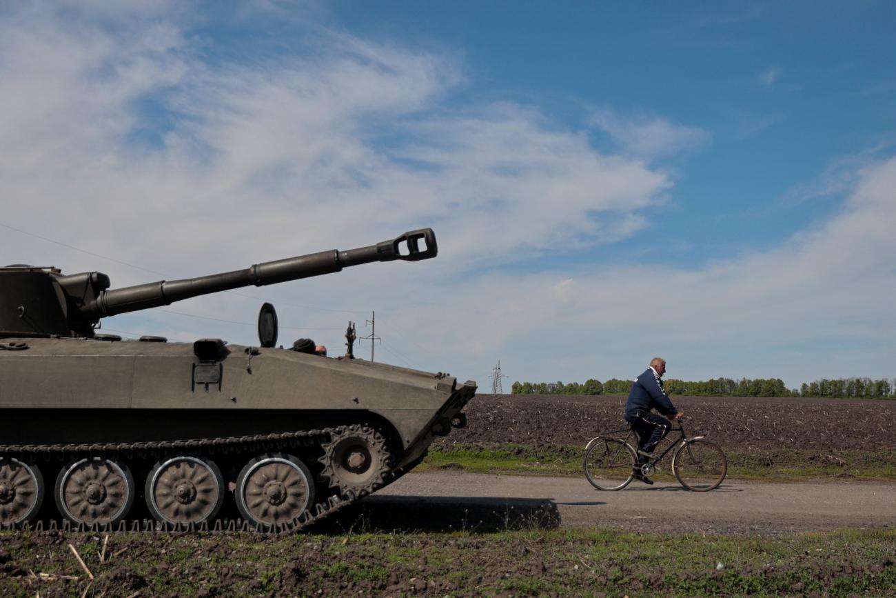 A local resident rides a bicycle past a self-propelled howitzer 2S1 Gvozdika, as Russia's attack on Ukraine continues, in unknown location in Kharkiv region, Ukraine May 7, 2022. 