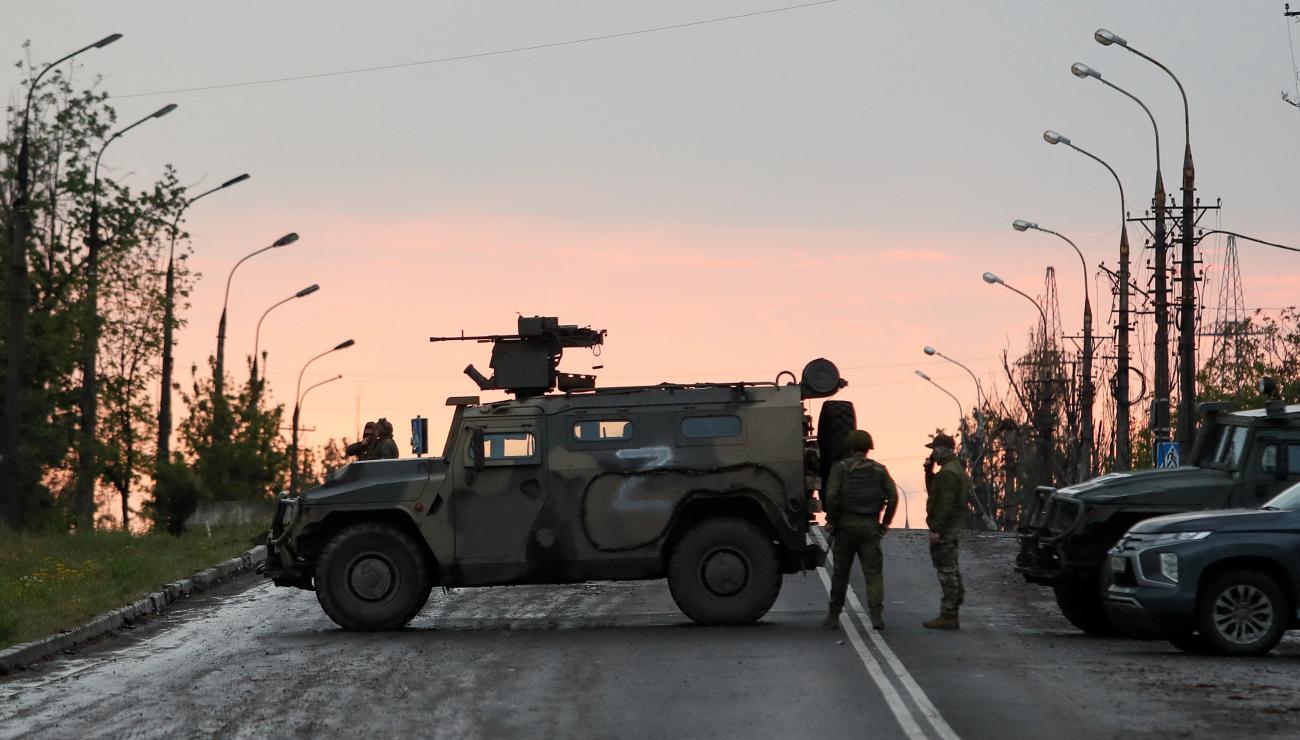 Service members of pro-Russian troops stand guard before the expected departure of Ukrainian soldiers, who surrendered at the besieged Azovstal steel mill, in the course of Ukraine-Russia conflict in Mariupol, Ukraine May 19, 2022.