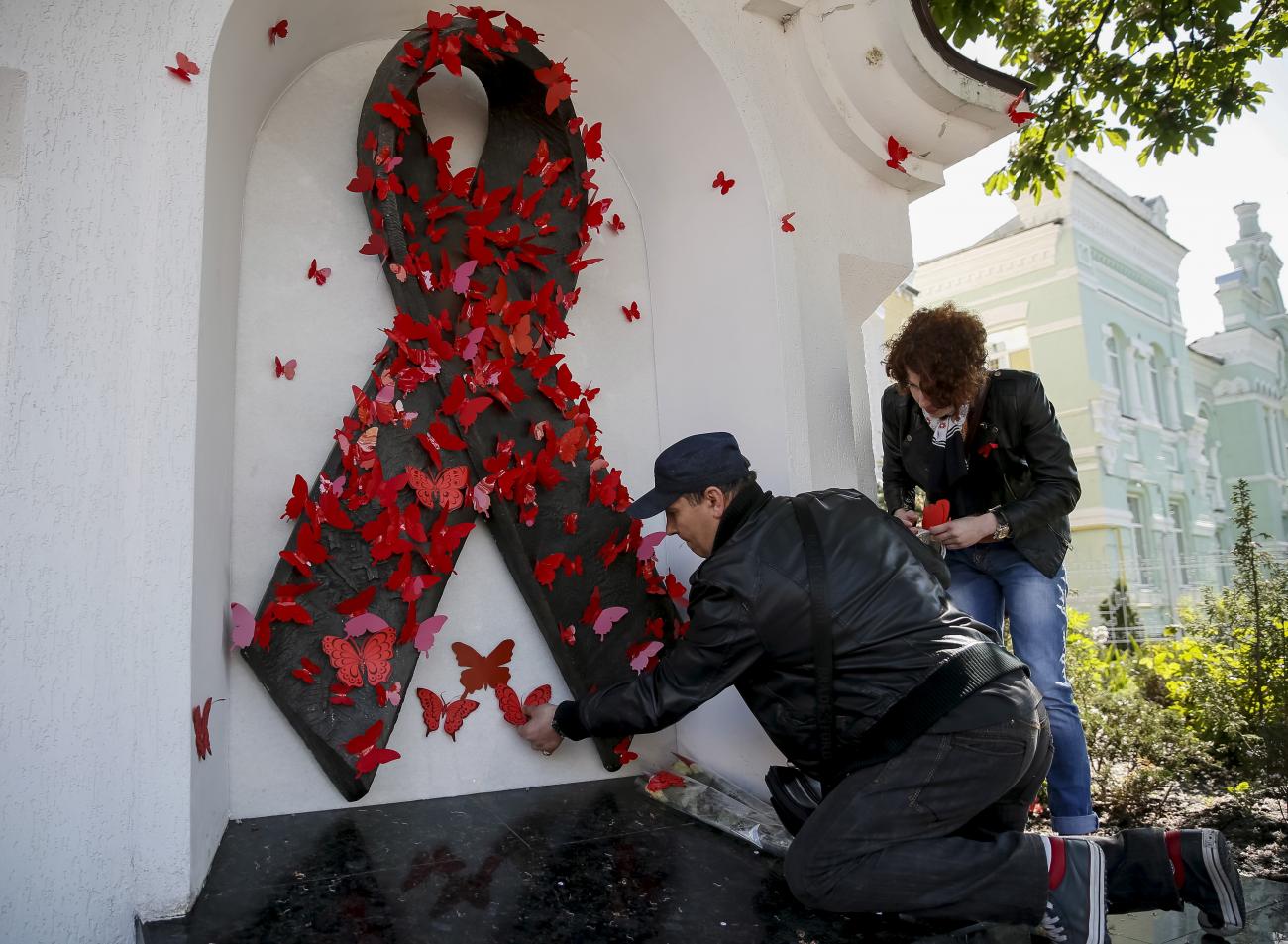 People affix symbolic red butterflies onto a monument in memory of people who have died of AIDS during a commemoration ceremony in Kyiv, Ukraine, on May 15, 2015. 