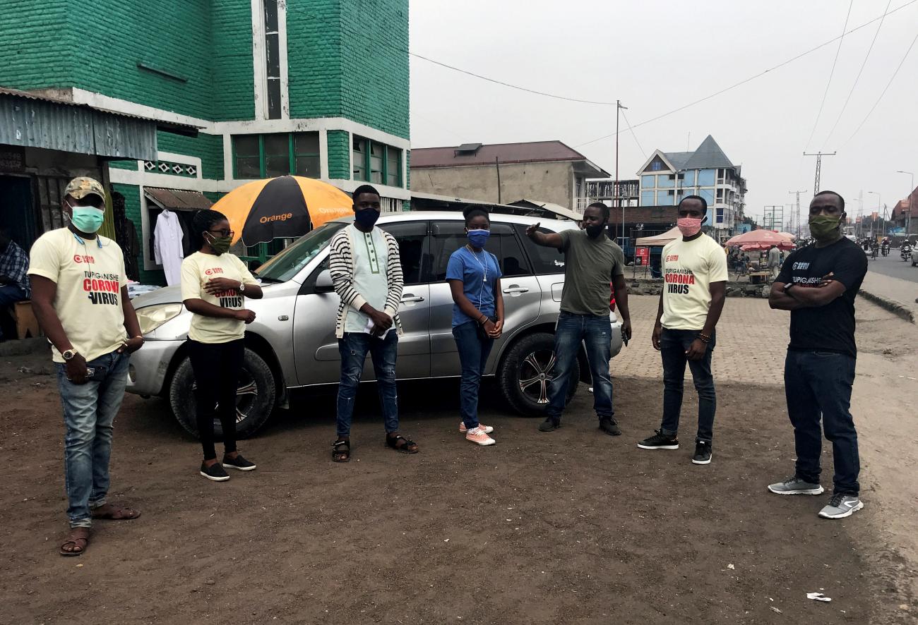 Volunteers of Goma Actif in masks and ivory t-shirts gather to teach people about the measures to prevent against the spread of COVID-19 within Ndosho quarters in Goma, eastern Democratic Republic of Congo on August 29, 2020. 