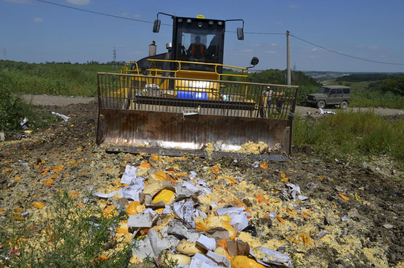 An employee operates a bulldozer, destroying illegally imported cheese, in the Belgorod region of Russia, on August 6, 2015.