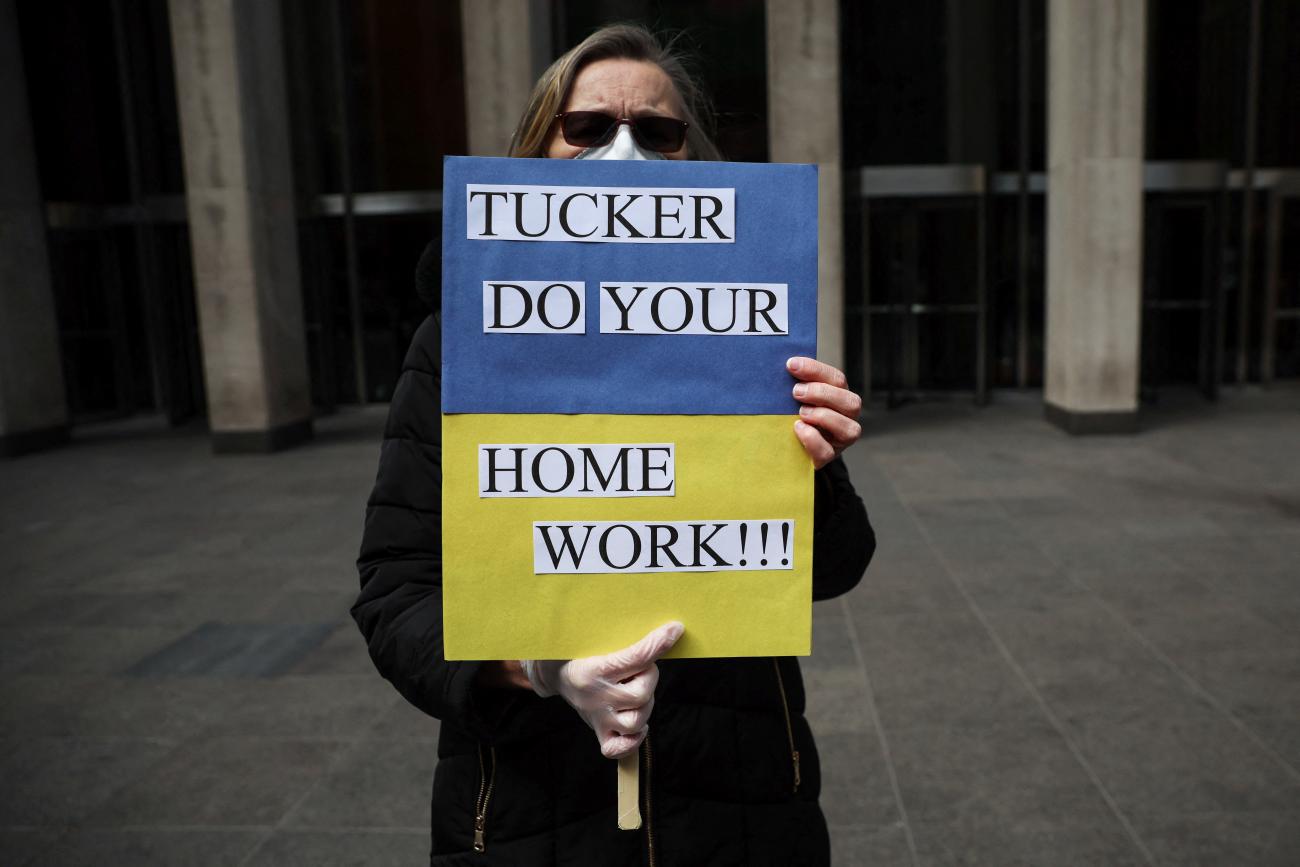 A woman stands outside the Fox News building protesting against Fox News host Tucker Carlson's coverage of Russia's attack on Ukraine in New York City, March 23, 2022. 