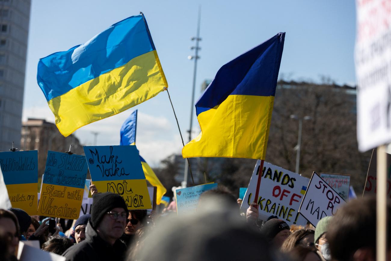 In response to Russia's attack on Ukraine, anti-war protestors wave light blue and bright yellow striped Ukrainian flags in front of the United Nations, in Geneva, Switzerland, on February 26, 2022. 