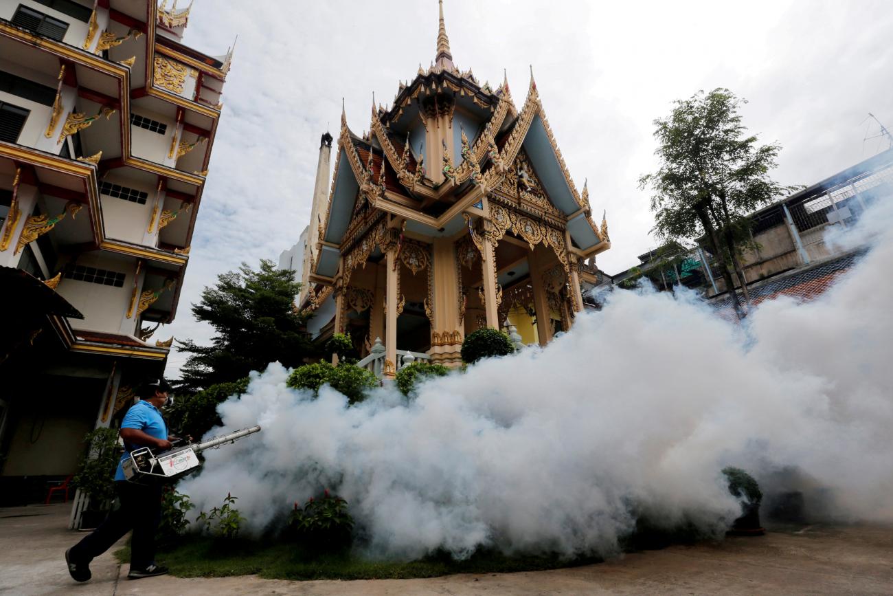 A city worker fumigates an area to control the spread of mosquitoes at a temple in Bangkok, Thailand, September 14, 2016.