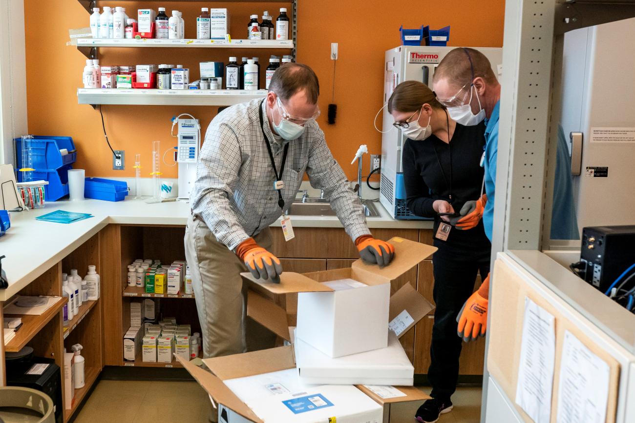 Pharmacists at the Chief Andrew Isaac Health Center unpack a new shipment of Pfizer COVID-19 vaccine doses in Fairbanks, Alaska, on March 30, 2021.