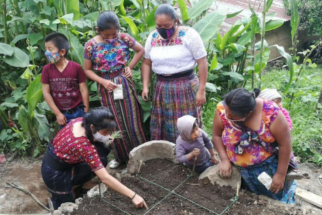 Marisol, 17, teaches a family how to construct a garden, in Sololá, Guatemala, in 2020.