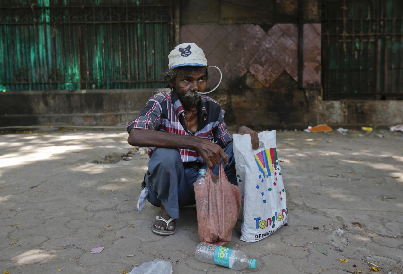 Cancer patient Philip Mokal sits on a pavement outside the Tata Memorial Hospital in Mumbai April 2, 2013. 