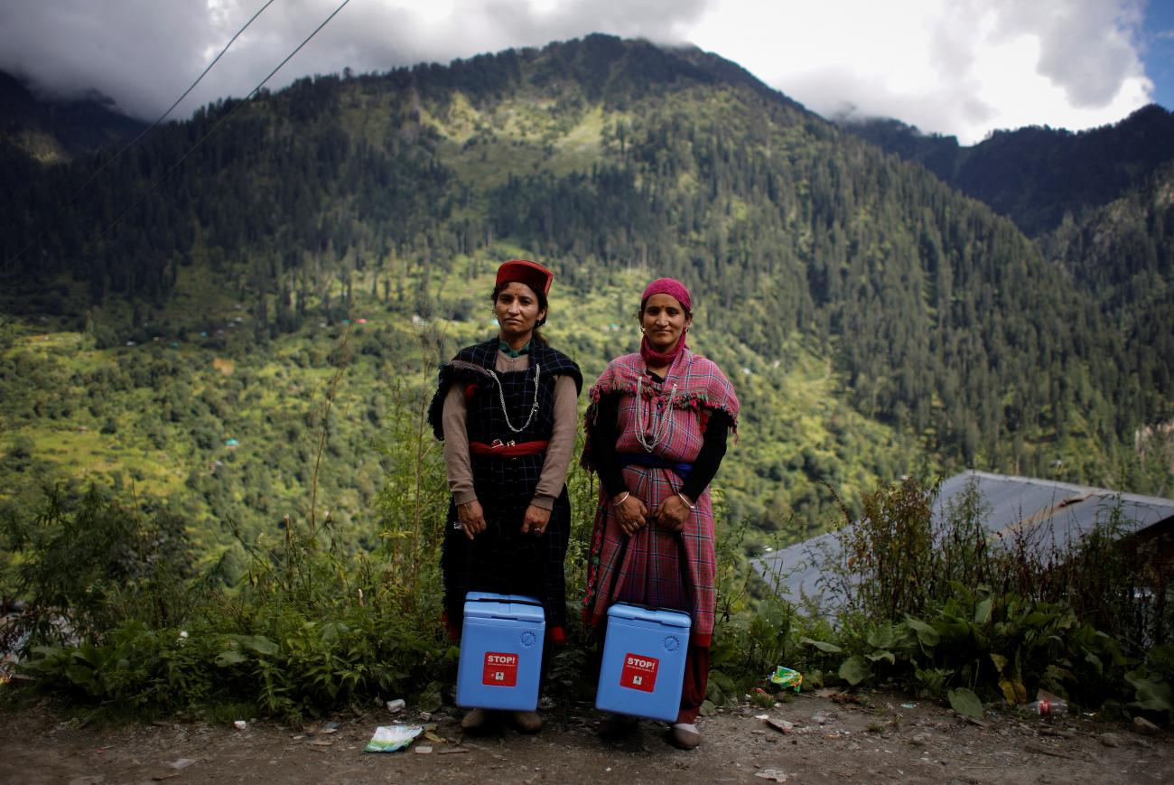 Mountains and a cloud sky loom behind health workers Nirma and Phula Devi who carry COVID vaccines in Malana village in the Kullu district, in the Himalayan state of Himachal Pradesh, India, on September 14, 2021. REUTERS/Adnan Abidi