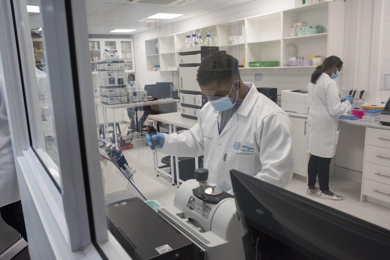 Scientists in white lab jackets work in a lab at Afrigen, in Cape Town, South Africa.